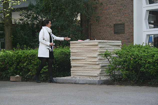 Eine Schülerin der Projektgruppe (Cansel Gülyaprak) legt einen Erinnerungsstein auf den Gedenkstein © Jutta Lohaus